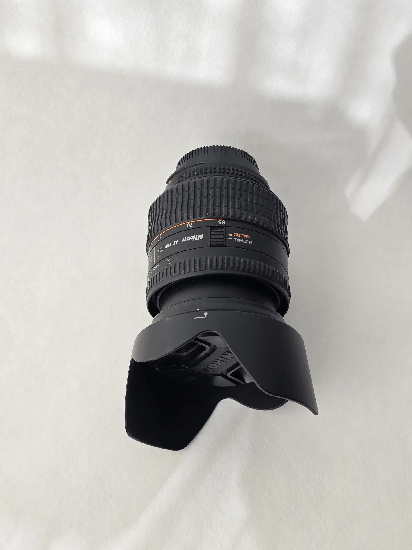 Objectif Nikon 24‑85mm f/2.8‑4D en vue latérale avec repères 70‑85mm et mode macro.