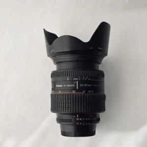 Objectif Nikon AF NIKKOR 24‑85mm f/2.8‑4D vu de face avec pare‑soleil.l