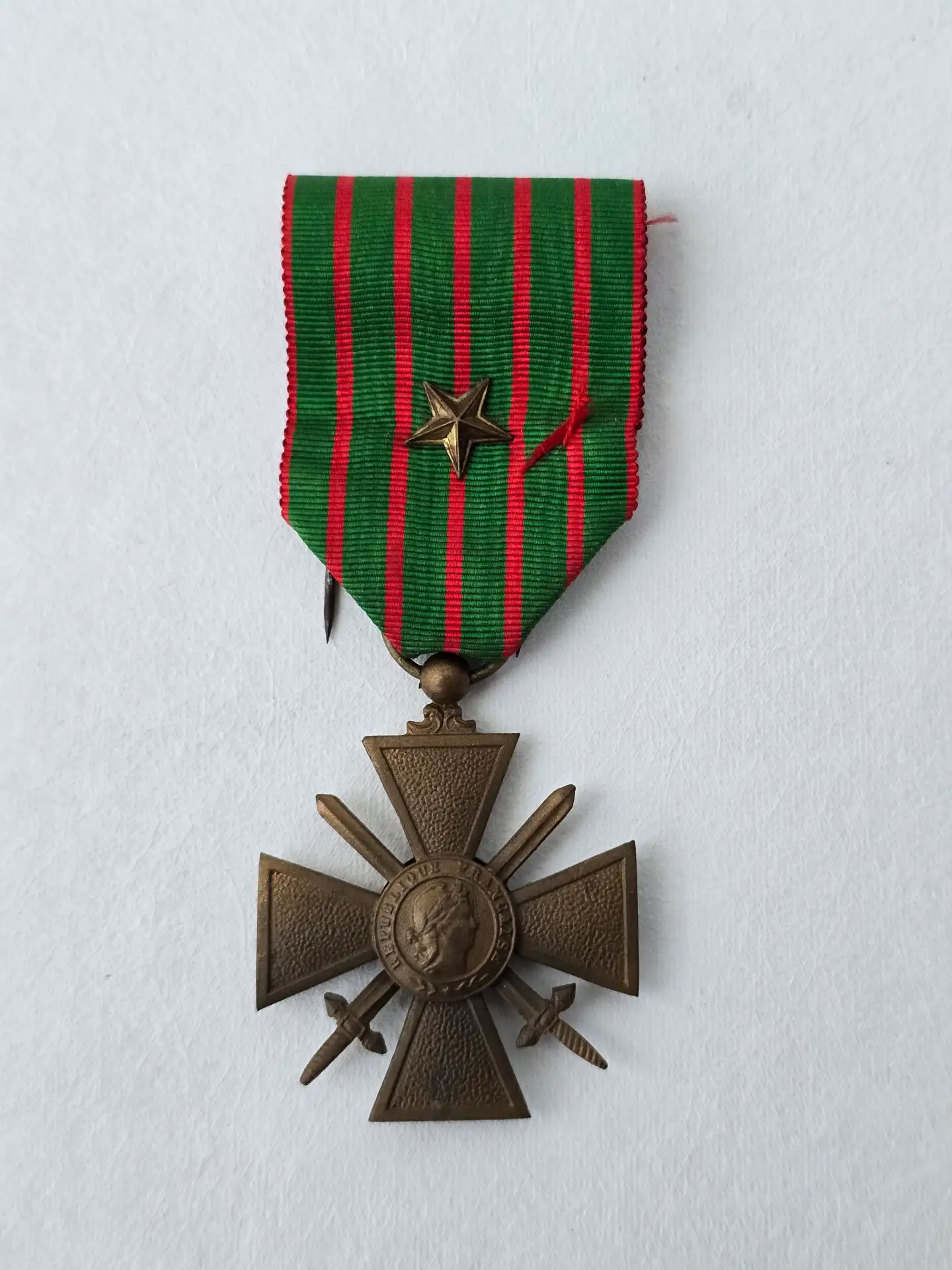 Croix de guerre 1914‑1918 française authentique, vue de face, bronze, ruban vert à raies rouges, épingle de fixation