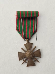Croix de guerre 1914‑1918 vue de dos avec étoile de bronze cousue, dates 1914‑1918 gravées, ruban vert rayé rouge