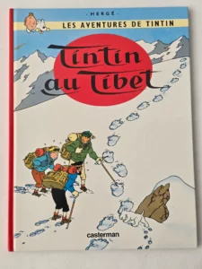 Couverture de Tintin au Tibet, édition Casterman vintage, avec Tintin et Milou marchant dans la neige vers les empreintes du yéti.