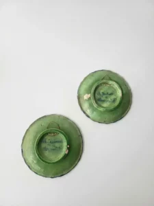 Verso de deux assiettes anciennes en faïence avec signatures Ch. Jaubert à Clermont‑Ferrand et attaches murales.