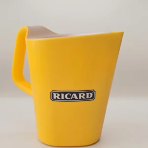 Pichet Ricard jaune publicitaire en plastique, vue latérale avec poignée, logo Ricard noir sur fond blanc, sur fond neutre.