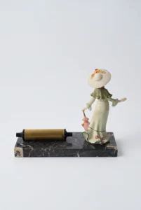 calendrier perpétuel vintage avec figurine femme vue arrière sur socle marbré
