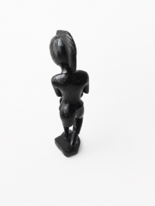 Statuette décorative en bois noir représentant un personnage africain, fond blanc.