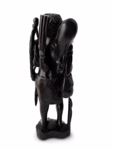 Vue arrière d’une statuette en bois sculpté noir montrant les détails du dos et des accessoires portés